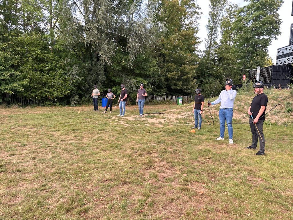 A group of professionals focused on learning the rules of ArrowTag, ready to engage in a unique and active team-building event designed to strengthen relationships and encourage collaborative fun.