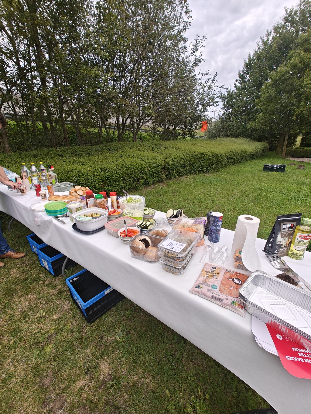 Food and drinks are lined up on a long table, ready for the BBQ feast.