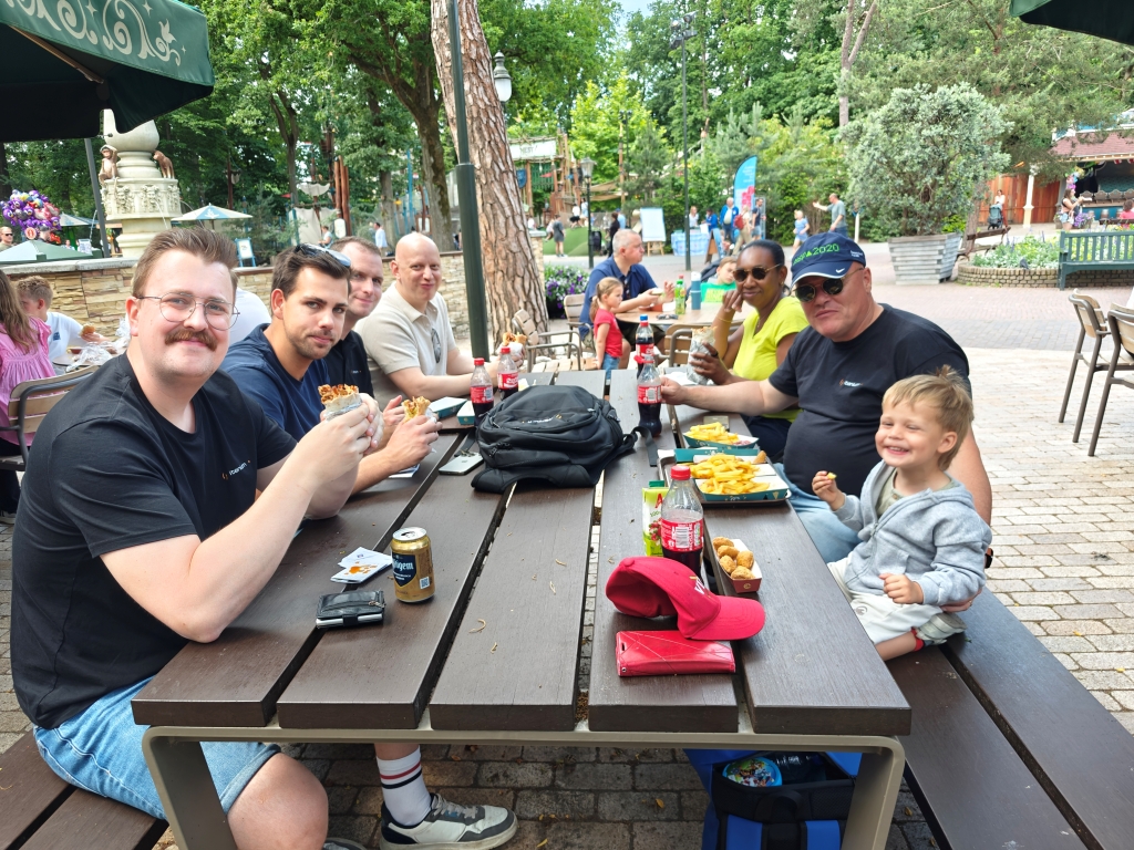 Itenium team members and their children sharing a delightful meal at Efteling's Family Day, creating cherished memories and strengthening team connections in a relaxed setting.