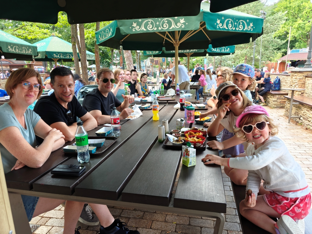 Itenium employees and their families enjoying a relaxing picnic together at Efteling, highlighting the friendly atmosphere and successful team-building aspect of the family day.