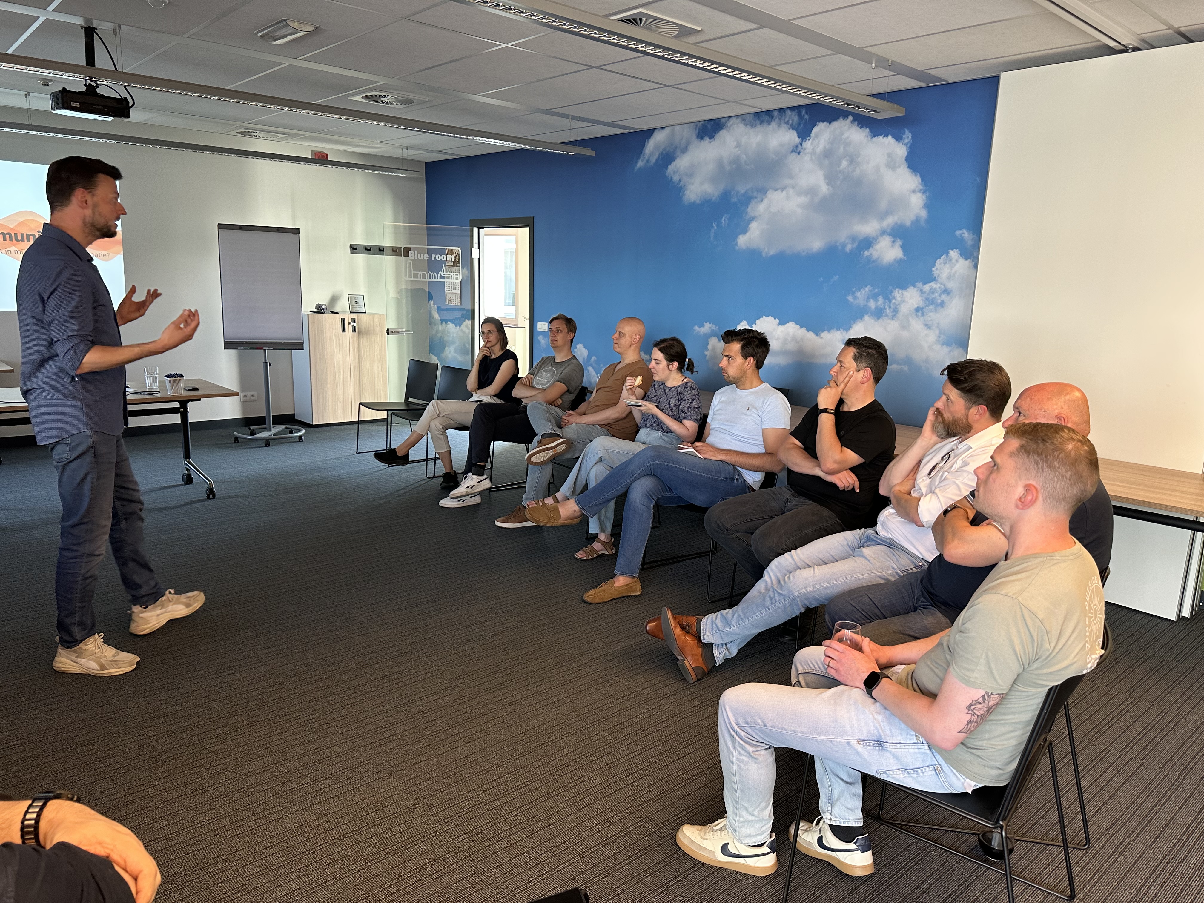 Developers and consultants attentively engaged in a **communication workshop**, learning techniques for **clarity and confidence** to master **stakeholder alignment** in project environments.