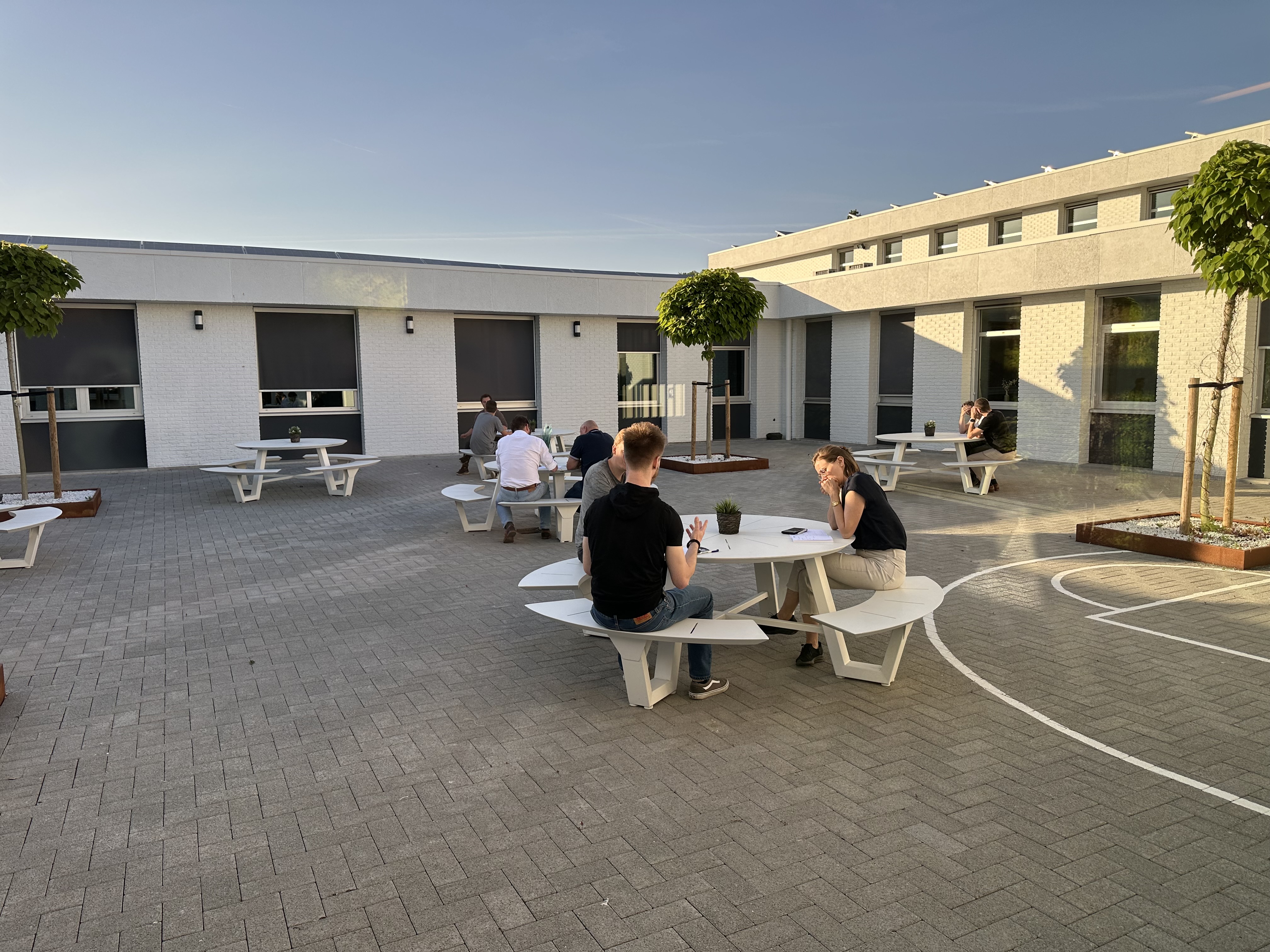 Team members engaging in an informal follow-up discussion outdoors, applying **soft skills** and **communication strategies** learned in the workshop to real-world project scenarios and **team collaboration**.