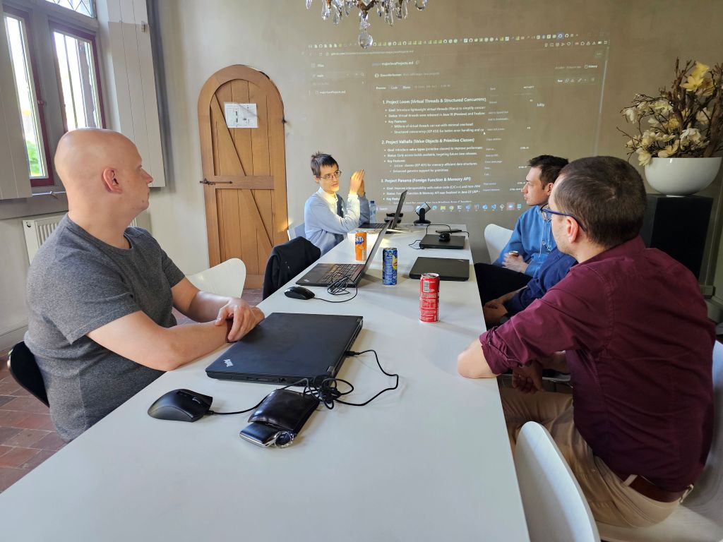 Developers immersed in an expert-led seminar, discussing and learning about the advanced features of Java from versions 17 to 24. This technical deep dive session fosters collaboration and understanding of modern Java programming.