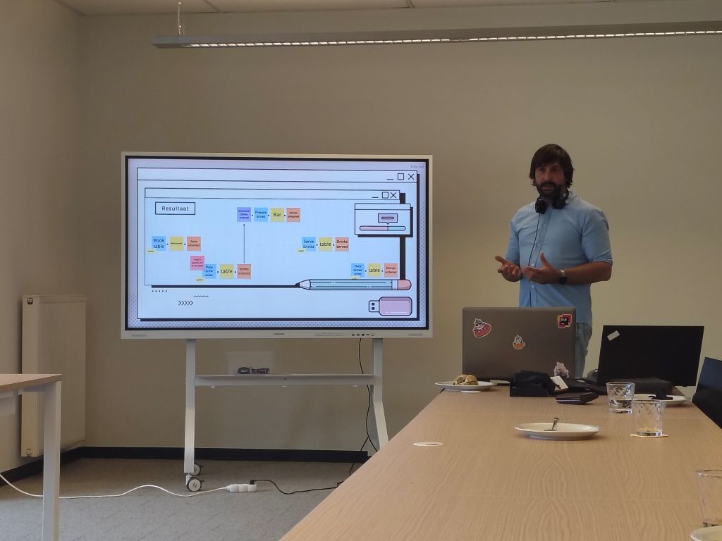 A speaker presenting a complex system diagram during the **Domain-Driven Design workshop**, delivering expert **DDD insights** on building cleaner and more robust software architecture.