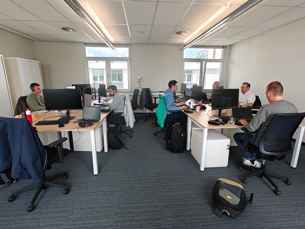 A focused software development team engaged in their daily work during an Office Day, collaborating and ensuring client project delivery. This showcases a productive and connected developer workspace.
