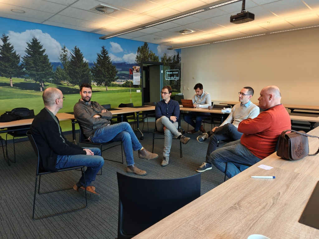 A group of Itenium consultants actively engaged in a focused Open Space discussion, sharing insights and collaborating on various topics. This image captures the essence of deep knowledge exchange and peer learning.