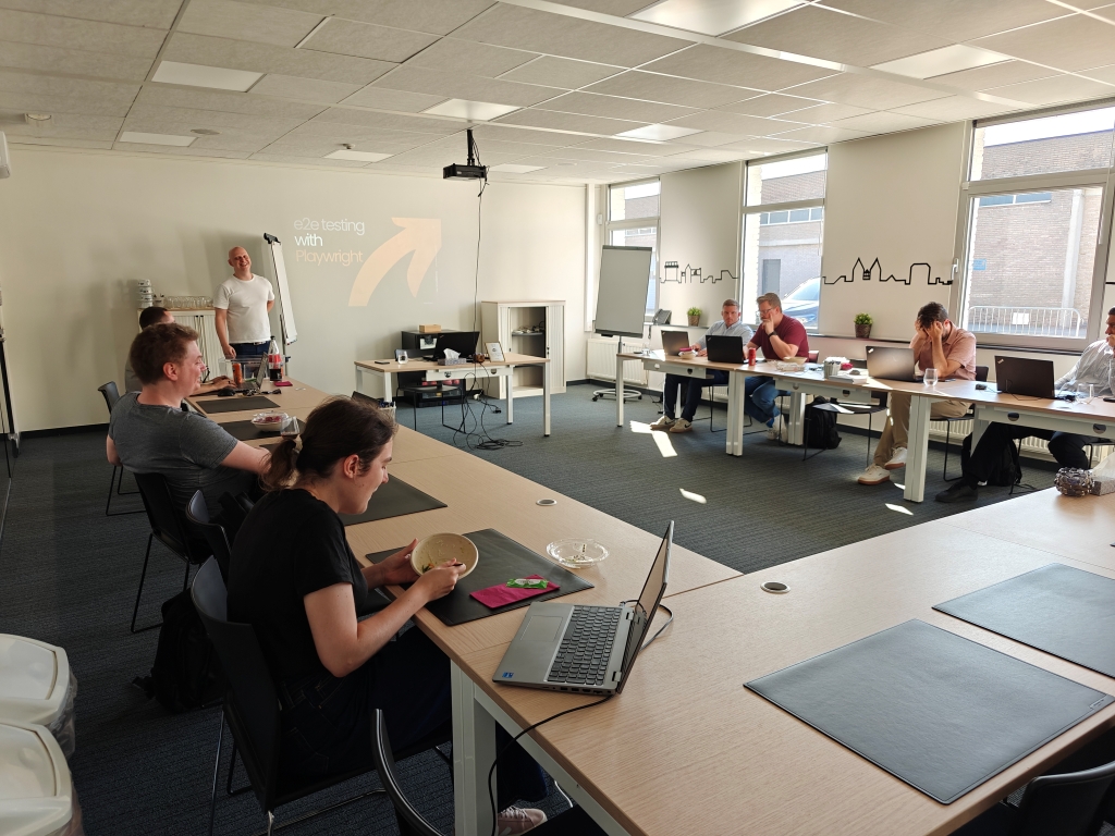 A speaker leading a practical workshop on e2e testing with Playwright, engaging a team of developers with hands-on exercises and real-world tips for modern software testing and CI integration.