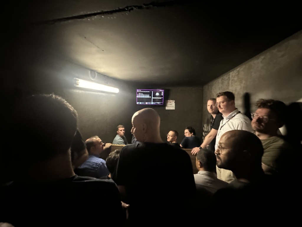 A focused team watches an escape room briefing video, learning essential strategies and tips for completing the challenging activity ahead.